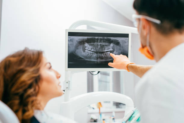 Dentist and patient looking at a digital dental x-ray. Kostenlose Erstuntersuchung 2